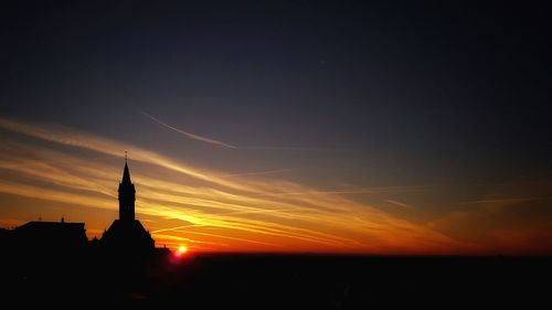 Silhouette city against sky at night