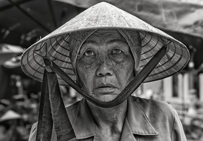 Portrait of senior woman wearing asian style conical hat