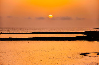 Scenic view of sea against orange sky