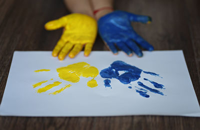 Child's hands painted on ukraine flag colors. peace for ukraine. stop war in ukraine.