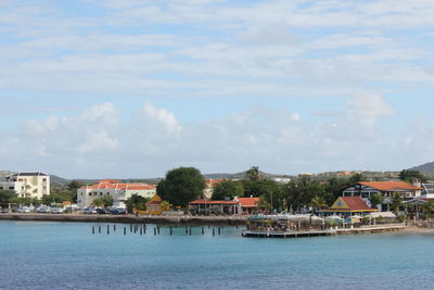 Houses by sea against sky