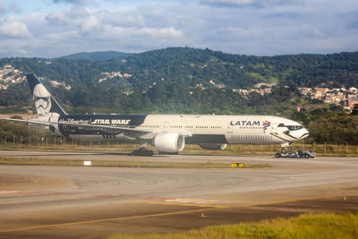 Airplane on runway against sky