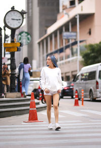 Rear view of woman walking on road in city