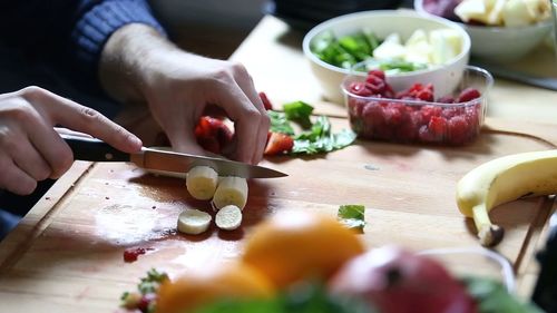 Man preparing food on cutting board, cutting bannana for prepare cooking