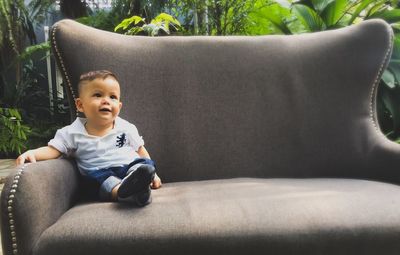 Cute boy sitting on sofa