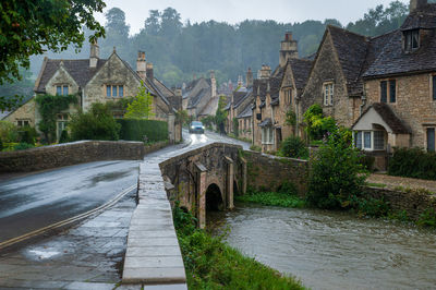 House by river amidst buildings in village