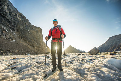 Beams of sunlight shine between a backpackers legs.