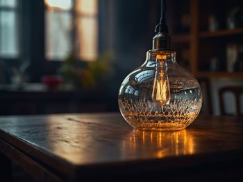 Close-up of illuminated light bulb on table