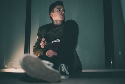 Man smoking while sitting on wall