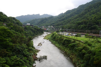 Scenic view of river amidst mountains against sky