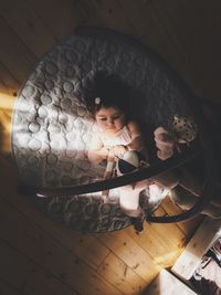 High angle view of cute girl lying on mat at home