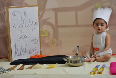 Portrait of cute girl standing on table