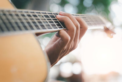 Midsection of woman playing guitar