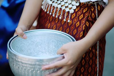 Midsection of woman holding containers