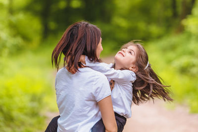 Rear view of mother and daughter outdoors