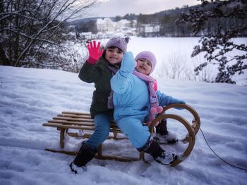 Full length of mother and daughter in snow during winter