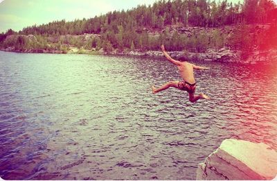 Silhouette of woman jumping in water