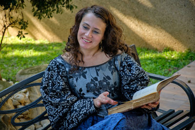 Portrait of a smiling young woman sitting outdoors