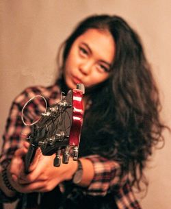 Portrait of young woman holding camera