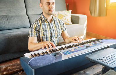 Young man sitting on sofa at home