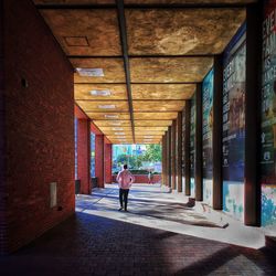 Rear view of woman standing in corridor of building