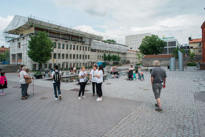 People on street in city against sky