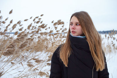 Portrait of young woman standing in snow