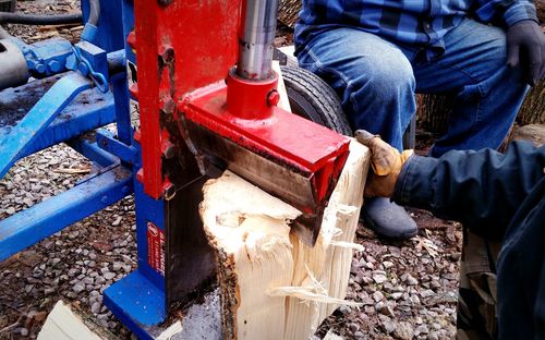 Cropped image of manual workers cutting wood