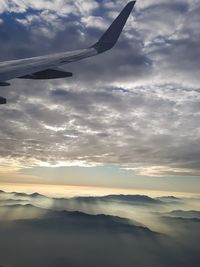 Airplane flying in sky during sunset