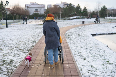 Rear view of man walking on snow