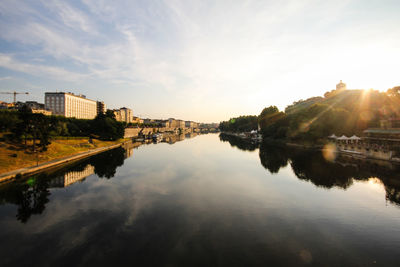 Reflection of buildings on river against sky