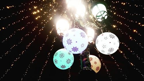 Low angle view of illuminated christmas lights hanging at night