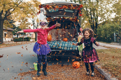 Trick or trunk. children siblings sisters celebrating halloween in trunk of car. friends kids 