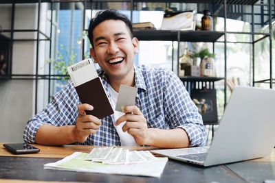 Man holding passport while sitting at home