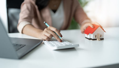 Midsection of woman using laptop on table