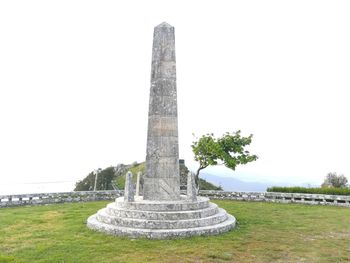 Stone structure on field against clear sky