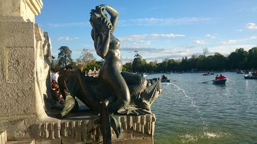 Statue by trees against sky