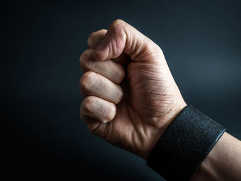 Cropped hand of person against black background