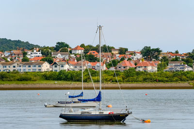 Boats moored in town against clear sky