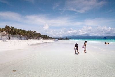 People on beach against sky