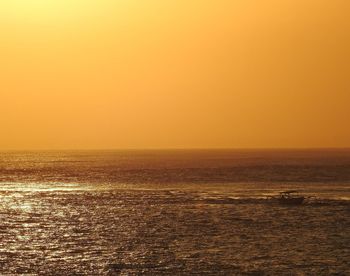 Scenic view of sea against orange sky