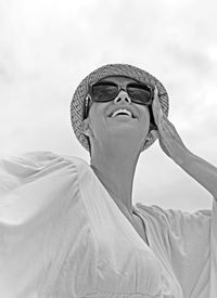 Low angle view of young woman against sky