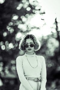 Portrait of young woman wearing sunglasses standing outdoors