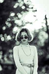 Portrait of young female model wearing sunglasses while standing outdoors