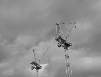 Low angle view of cranes against sky