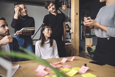 Midsection of businesswoman with coworkers at workplace