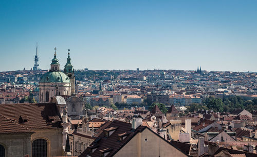 Aerial view of buildings in city against clear sky