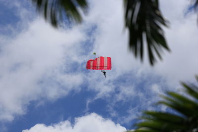 Low angle view of person flying with parachute in sky