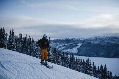 Rear view of person on snowcapped mountain against sky