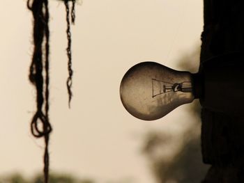 Close-up of old light bulb against sky